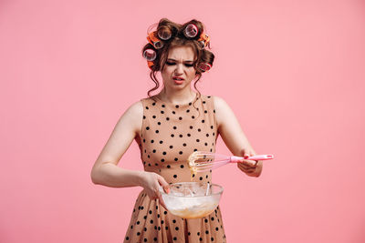 Portrait of woman with pink hair against colored background