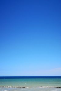 Scenic view of sea against clear blue sky