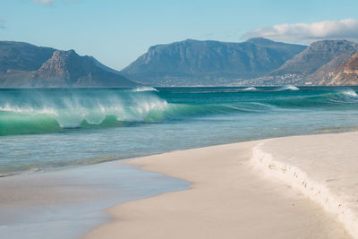 Scenic view of sea and mountains against sky