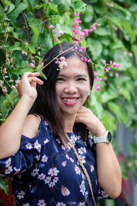 Portrait of smiling woman by plants