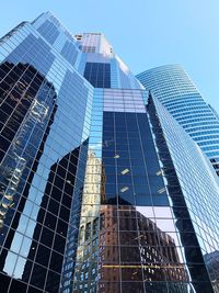 Low angle view of modern glass building against clear sky