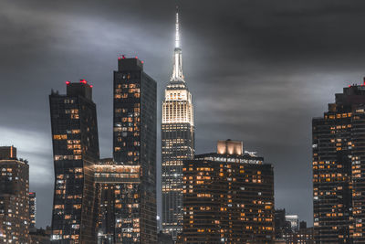 Illuminated buildings in city against sky at night