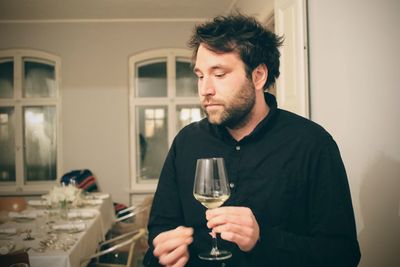 Thoughtful man looking down while holding wineglass
