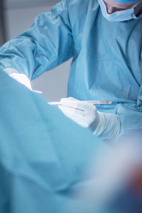 Midsection of doctor performing surgery at hospital