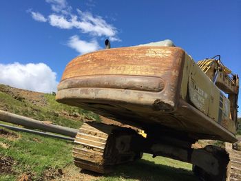 Low angle view of abandoned vehicle on landscape