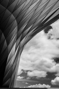 Low angle view of suspension bridge against cloudy sky