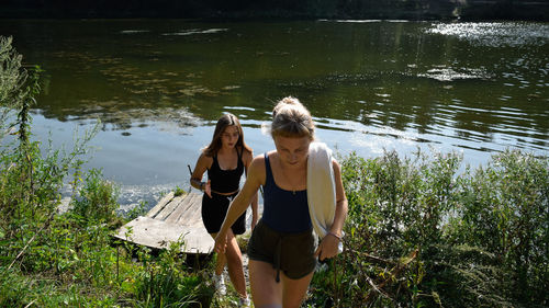 Rear view of woman standing by lake