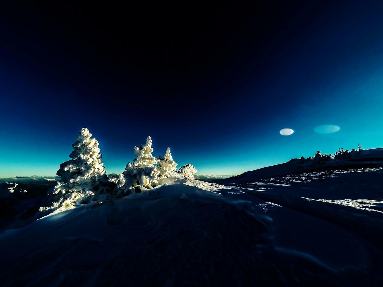 night, illuminated, clear sky, snow, blue, winter, copy space, cold temperature, building exterior, moon, architecture, built structure, sky, lighting equipment, outdoors, scenics, dusk, city, street light, nature