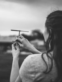 Cropped image of woman playing with fan toy