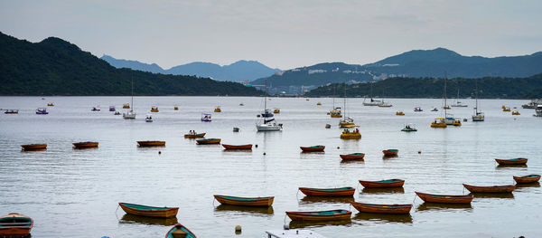 Boats moored in sea against sky