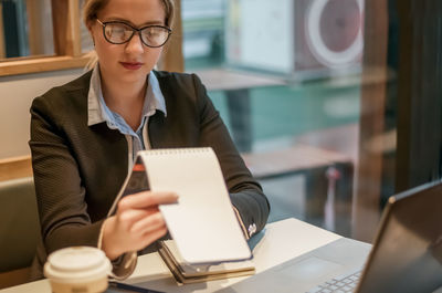 Portrait of young businesswoman using laptop at office