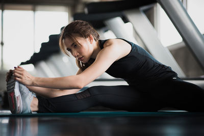 Young woman exercising in gym