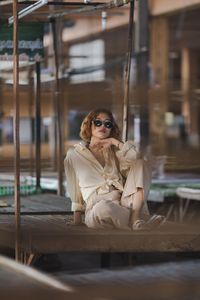 Portrait of young woman sitting on wood