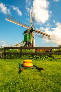 Traditional windmill on field against sky