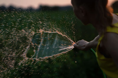 Midsection of man holding leaf in water