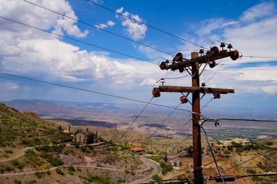 Electricity pylon on land against sky