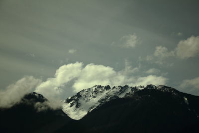 Low angle view of snowcapped mountains against sky