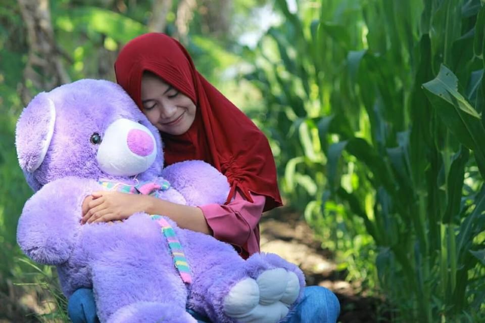 PORTRAIT OF A SMILING GIRL WITH TOY