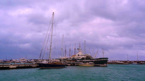 Sailboats moored in sea against sky