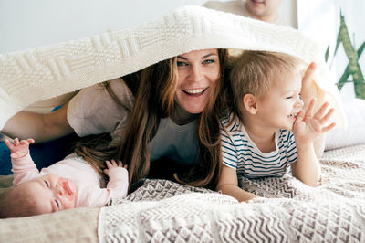 Mother and baby girl lying on bed