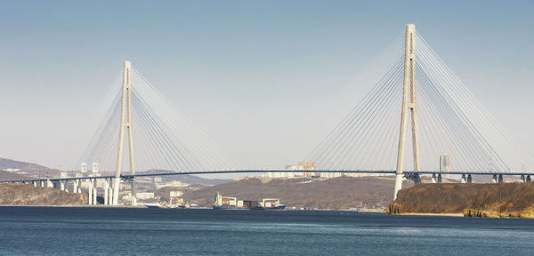 Suspension bridge over river against sky