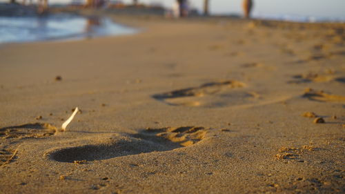 Close-up of footprints on sand at beach