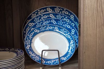 Close-up of plates in rack on shelf