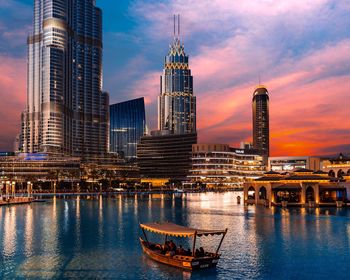 View of buildings at waterfront against cloudy sky