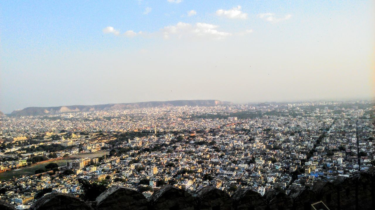 HIGH ANGLE VIEW OF ILLUMINATED BUILDINGS IN CITY AGAINST SKY