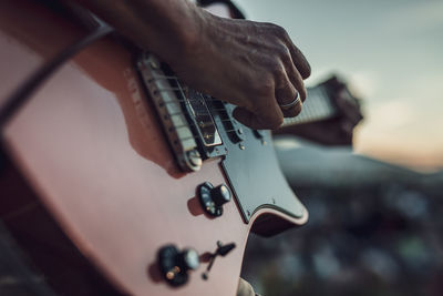 Cropped hand of man playing guitar