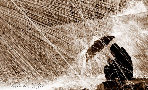 Blurred motion of woman standing in water at night