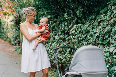 Portrait of a mother and a six-month-old baby walking on a summer day.