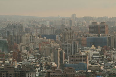 Aerial view of buildings in city against sky