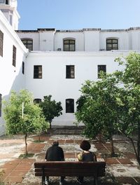 Rear view of man sitting against building