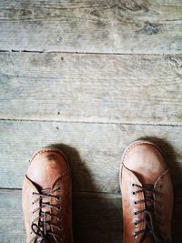 Low section of man standing on wooden floor