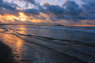 Scenic view of beach against sky during sunset