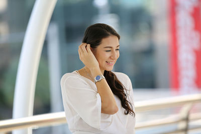 Woman looking away while standing outdoors