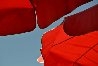 Low angle view of red umbrella against clear sky