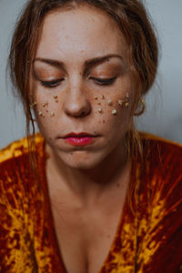 Close-up young woman with dried flowers on face