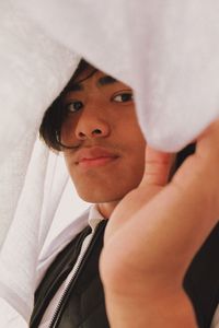 Portrait of teenage boy under blanket