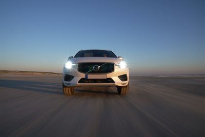 Vintage car on road against clear blue sky