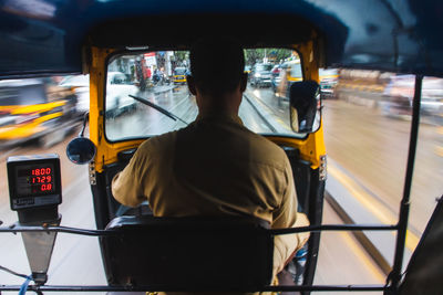 Rear view of man traveling in bus