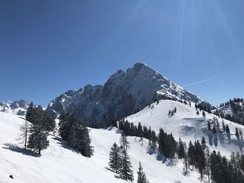 Scenic view of snowcapped mountains against clear blue sky