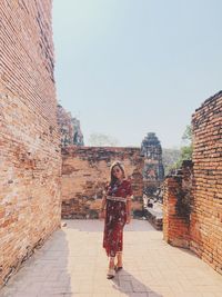 Full length of woman standing against the wall