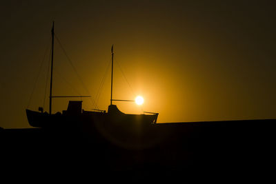 Silhouette sailboat against sky during sunset