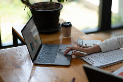 Midsection of woman using laptop on table