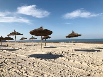 Umbrellas on beach against sky