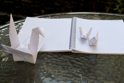 Close-up of paper swan on book at table