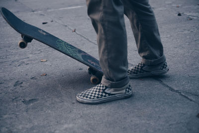 Low section of man skateboarding on road