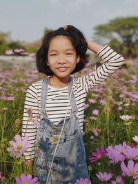 Portrait of a smiling girl standing against plants